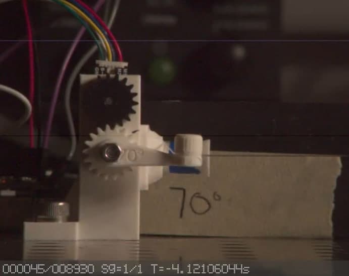 Geared latch-release mechanism on a test rig marked with angle references